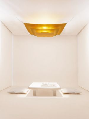 Goldene Lil Luxury Deckenleuchte von Ingo Maurer in minimalistischem, hellem Raum mit niedrigem Tisch.